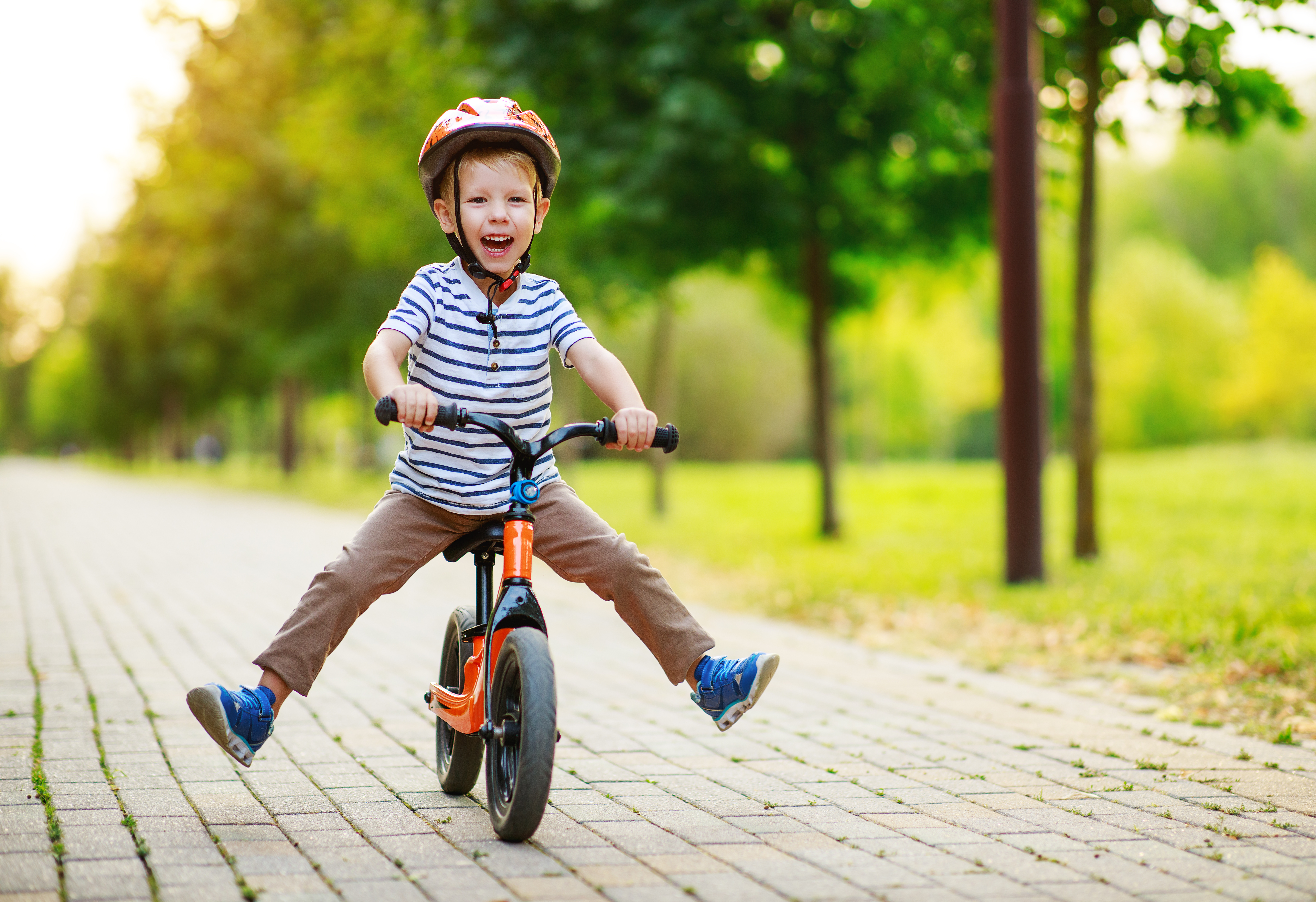 Child riding a bike outside, smiling having fun